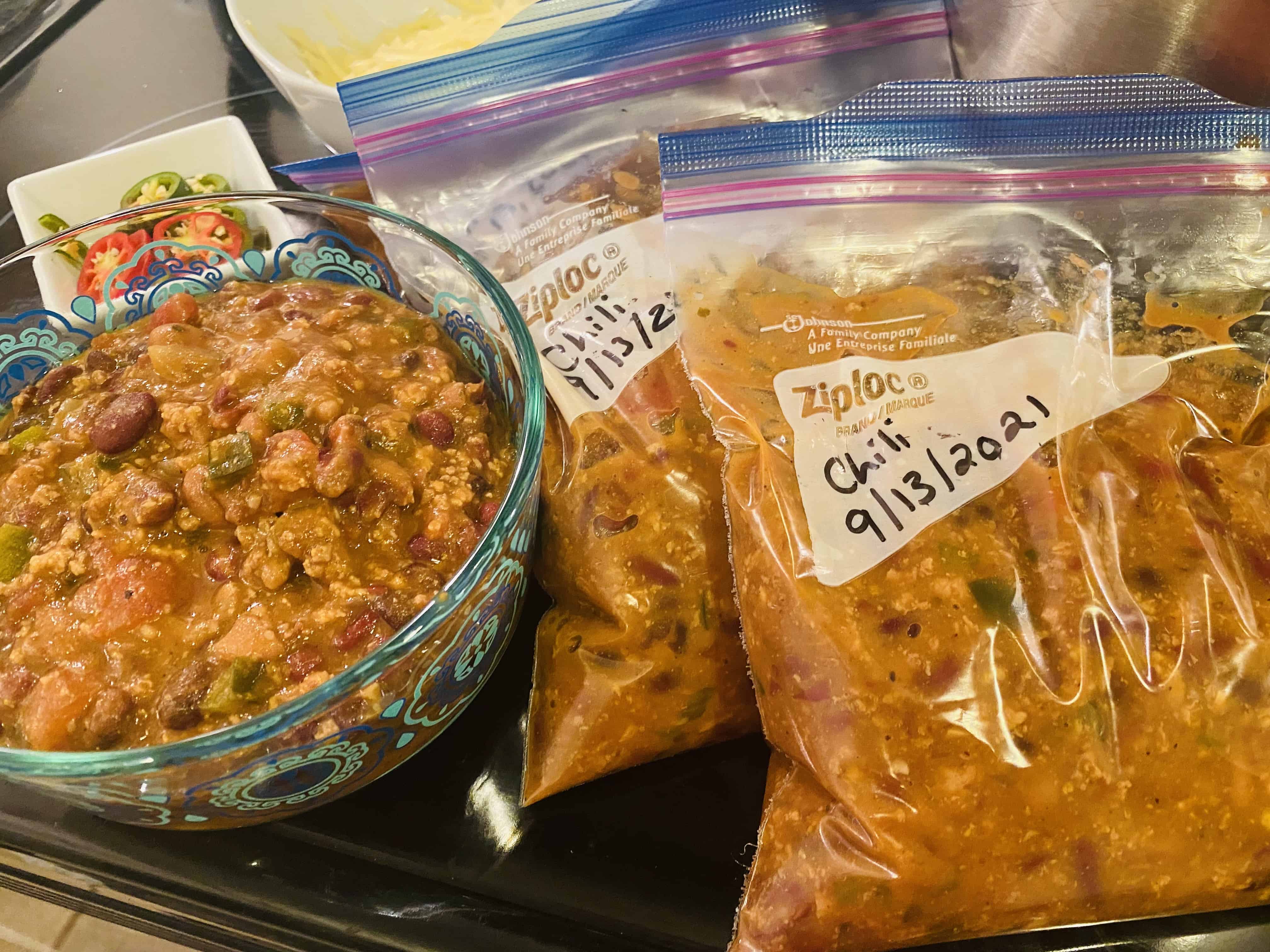 meal prepped chili in bowl and in freezer bags