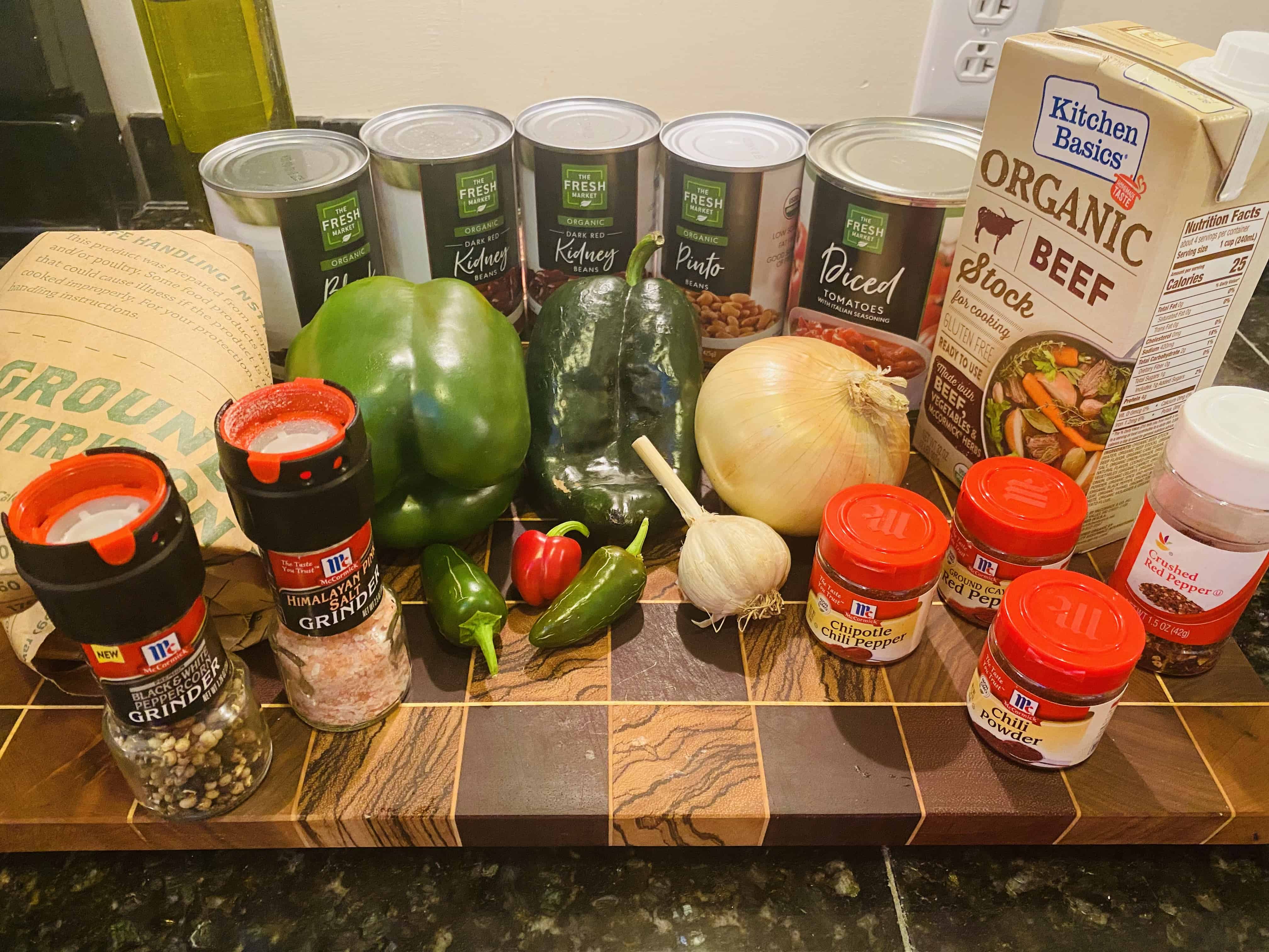 ingredients for chili: ground beef, canned beans, peppers, onion, garlic, beef broth, spices