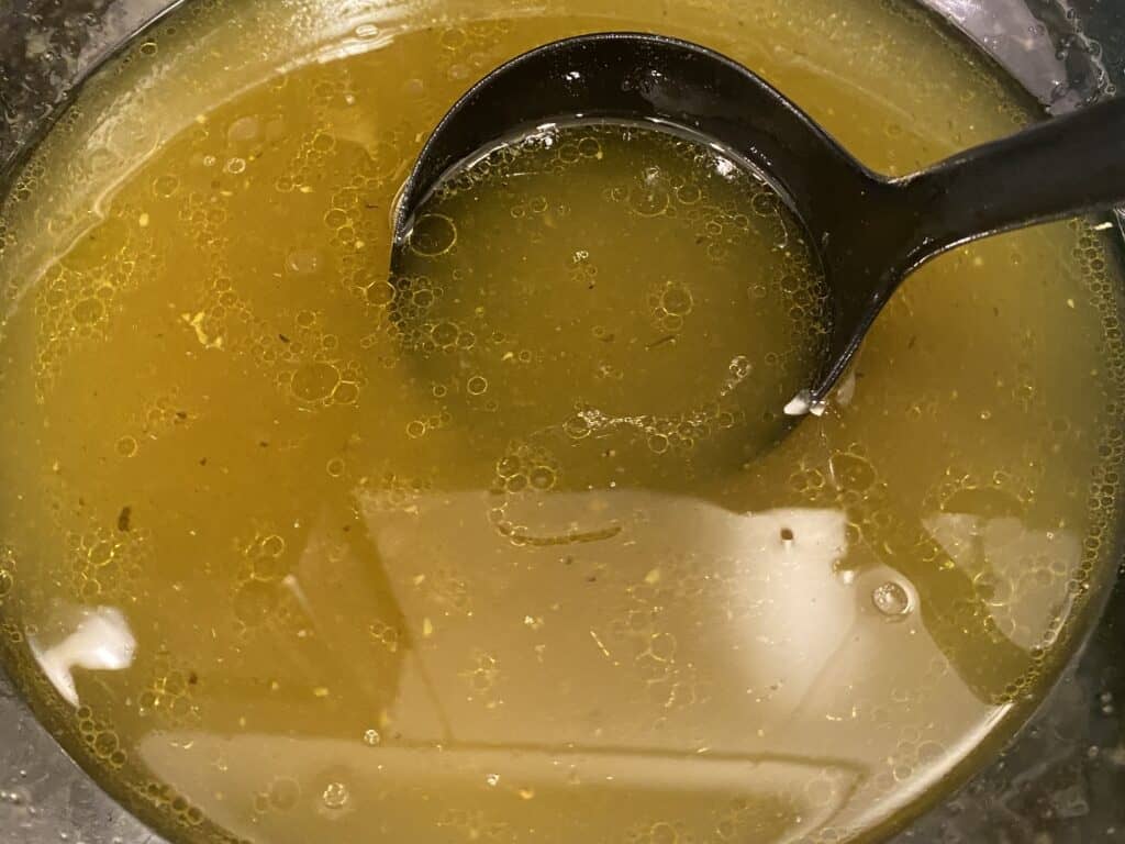 scoop of homemade chicken stock