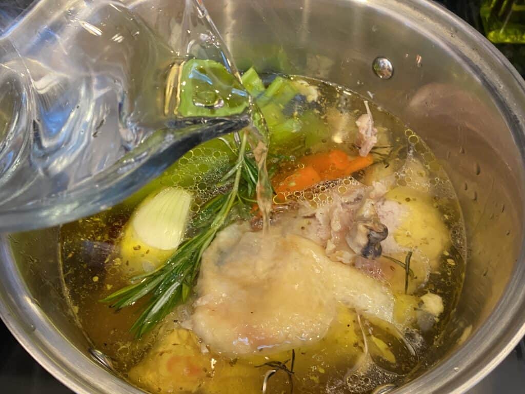 pouring water into chicken stock pot